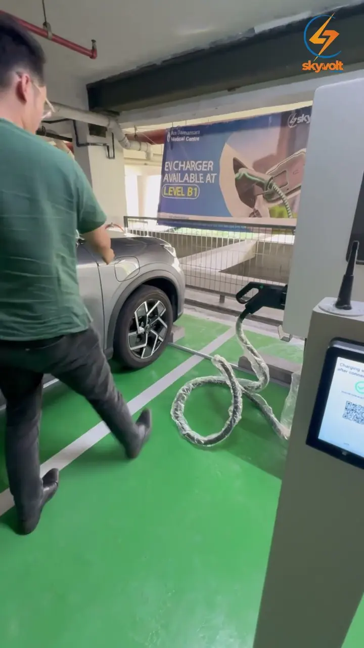 Driver walking up to a SkyVolt DC fast charger at Ara Damansara Medical Centre